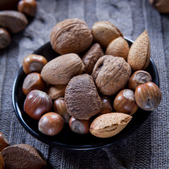 Mixed nuts in shells on the natural background: hazelnut, walnut, Brazil nut and almond.