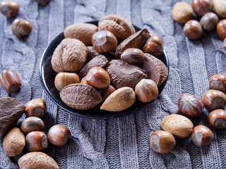 Mixed nuts in shells on the natural background: hazelnut, walnut, Brazil nut and almond.