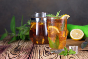 Glass of iced tea with mint and lemon. Cold drink. Rustic style