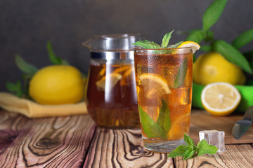 Glass of iced tea with mint and lemon. Cold drink. Rustic style