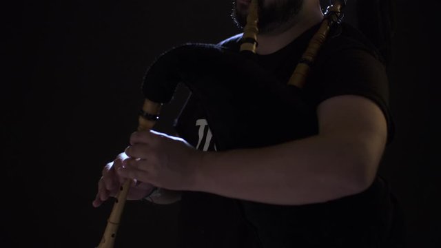some hands play a bagpipe
