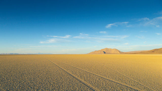 Vast Desert Playa at Black Rock Nevada At Sunset with Tire Tracks on Empty Cracked Mud.