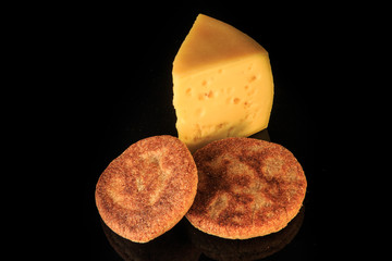 top view of hard yellow cheese piece with two rye flapjacks
