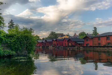 The colorful red wooden warehouses of Porvoo in Finland reflecting in the river at sunset during a warm summer evening - 6