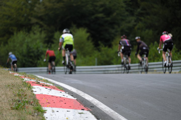 Fototapeta na wymiar Radrennfahrer beim Radsport-Festival auf dem legendären Nürburgring im Streckenabschnitt Pflanzgarten auf der Nordschleife - Stockfoto