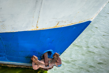 A rusty anchor on the side of a fishing ship in Helsinki