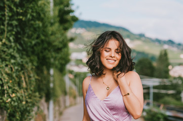 Fototapeta premium Happy young woman dancing on the street, wearing purple dress, happiness and freedom