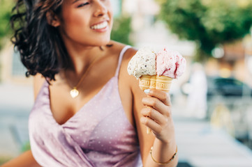 Double cone ice cream holding by young beautiful woman, Stracciatella and Bubble Gum taste