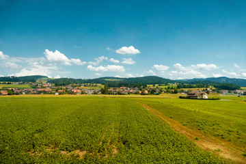 Traditional rural landscape with small houses and green fields in Switzerland