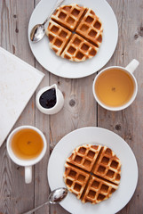 Breakfast - waffles and tea on a wooden table