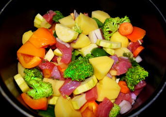 Raw vegetables and beef in a pan ready for cooking 