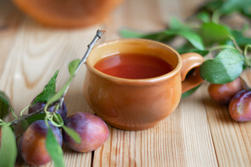 Sweet red plums with leaves on the wooden rustic table, selective focus