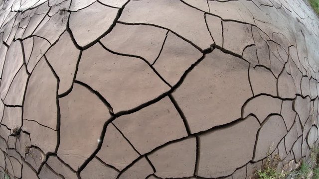 Panning over muddy cracks with fisheye view after flood.