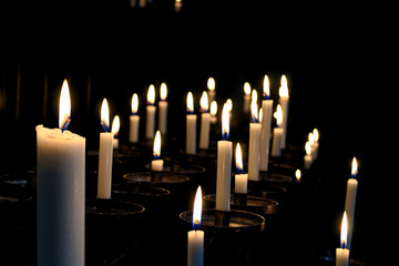 White candels in a church in the darkness.