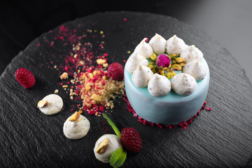 Cheesecake with raspberries and nuts on a black background