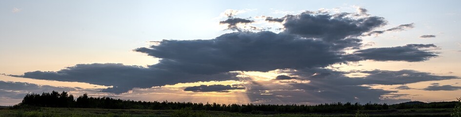 Panorama Sunset - Sun Hiding Behind Dark Clouds Creating God Rays