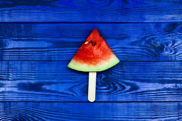 Fototapeta na wymiar Watermelon slice popsicles with ice cream stick on blue wooden background. summer fruit background.