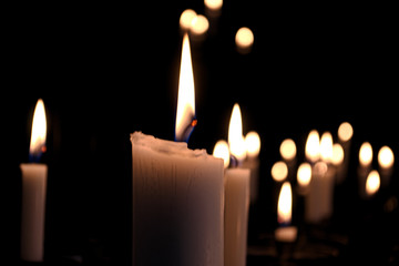 white candles in the Church on a dark background close-up