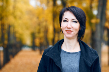 Beautiful woman posing in autumn city park, fall season, yellow leaves