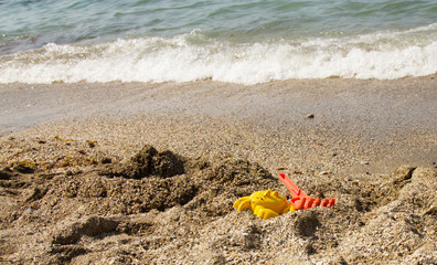 Children's toys on a sandy beach on the beach. Vacation with a child at sea in southern countries..