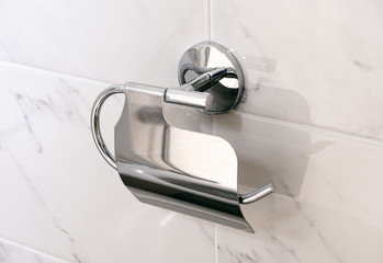 Empty toilet paper holder on wall.