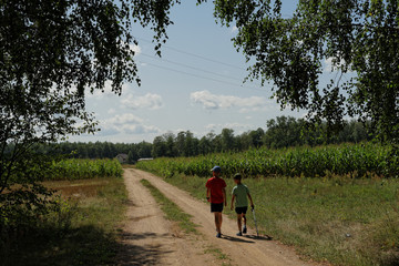 dwaj chłopcy idą na wycieczkę przez pola uprawne  © ftomasz