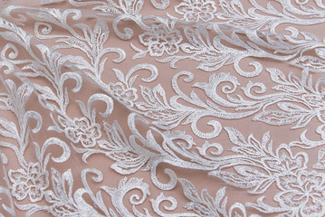 Texture lace fabric. lace on white background studio. thin fabric made of yarn or thread. a background image of ivory-colored lace cloth. White lace on beige background.