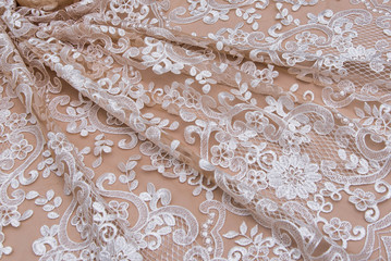 Texture lace fabric. lace on white background studio. thin fabric made of yarn or thread. a background image of ivory-colored lace cloth. Beige lace on beige background.