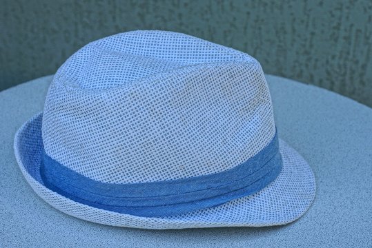 white summer men's hat lies on a gray table