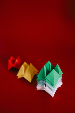 Multicolored origami fortune tellers on red background