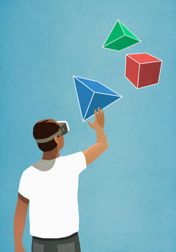 Man with virtual reality simulator glasses looking up at 3D geometric shapes
