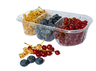 berries of red and white currants and blueberries in plastic packaging.