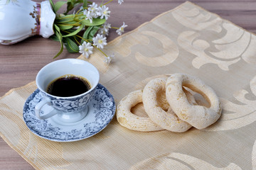 cup of coffee with cookie on table with background