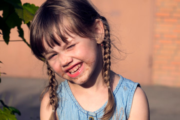 Little Muddy girl. Little naughty girl face smeared in chocolate
