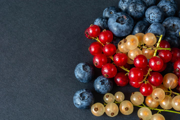 berries of red and white currants and blueberries in plastic packaging.