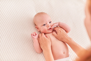 gymnastics baby. woman doing exercises with baby for its development. massage a small newborn baby.