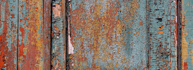 Multilayer paint. Peeling paint on a wooden surface. Texture of the old cracked paint. Cracked paint on a wooden surface
