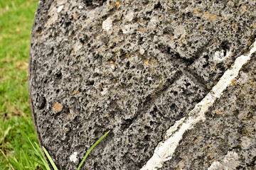 Christian cross symbol carved in old stone element.