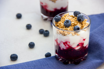 Granola with yogurt and blueberries over bright background