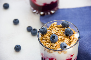 Granola with yogurt and blueberries over bright background