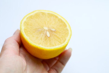 half of lemon with seeds in woman hand