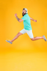 Fototapeta premium Impetuous movement. Hipster dancing jumping headphones gadget. Inspiring song. Music library. Energy of rhythm. Bearded guy enjoy music. Music fan. Man listen music wireless headphones in motion