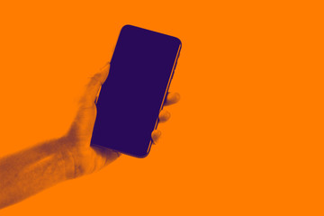 Female hand holding black cellphone with white screen at isolated background.