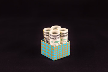 money in gift box on black background