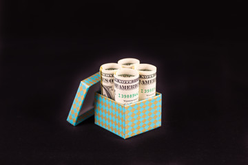 money in gift box on black background