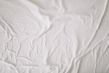 Fabric texture background. Wrinkled, crumpled fabric. Top view of unmade bed sheet after night sleep. Soft focus
