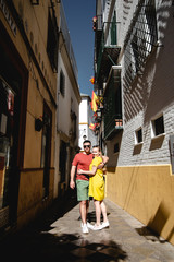 Traveling young couple walking around old city centre. Beautiful tourist visiting historic city on holiday. Man and woman cuddling and enjoying trip in Portugal. Sweet pair walking in narrow street