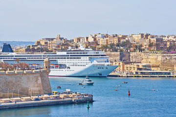 General view of Valletta Grand harbor in Malta with large cruise liner ship in sea bay.