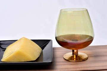 glass of alcoholic drink with cheese on the table on white background