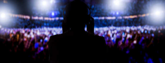 Dj with headphones mixing on a stadium